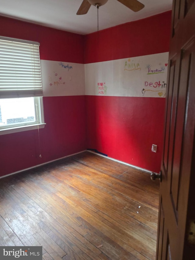 empty room with hardwood / wood-style floors and ceiling fan