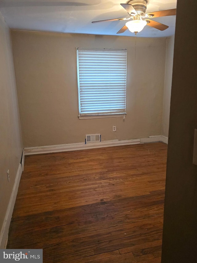 empty room with ceiling fan and dark hardwood / wood-style flooring