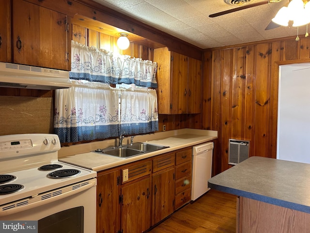 kitchen featuring sink, white appliances, light hardwood / wood-style flooring, ceiling fan, and wooden walls