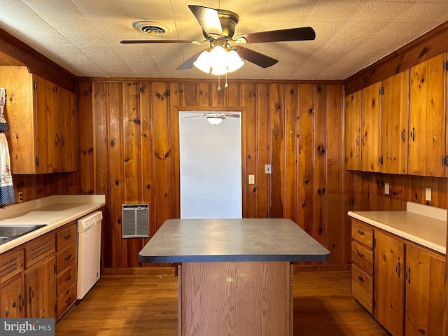 kitchen featuring a kitchen island, dark hardwood / wood-style floors, heating unit, dishwasher, and ceiling fan