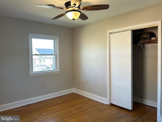 unfurnished bedroom featuring a closet, dark hardwood / wood-style floors, and ceiling fan