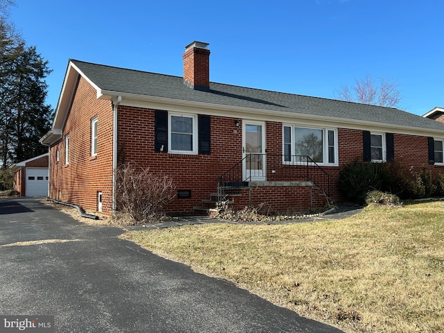 view of front facade with a garage, an outdoor structure, and a front yard