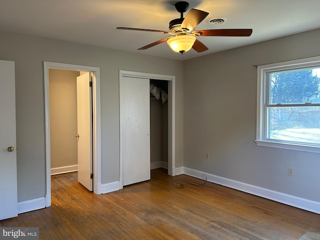 unfurnished bedroom featuring hardwood / wood-style flooring, a closet, and ceiling fan