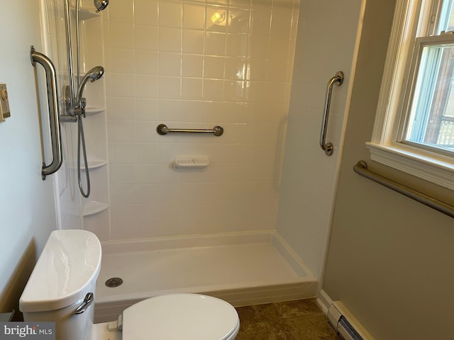 bathroom featuring a tile shower, toilet, and baseboard heating