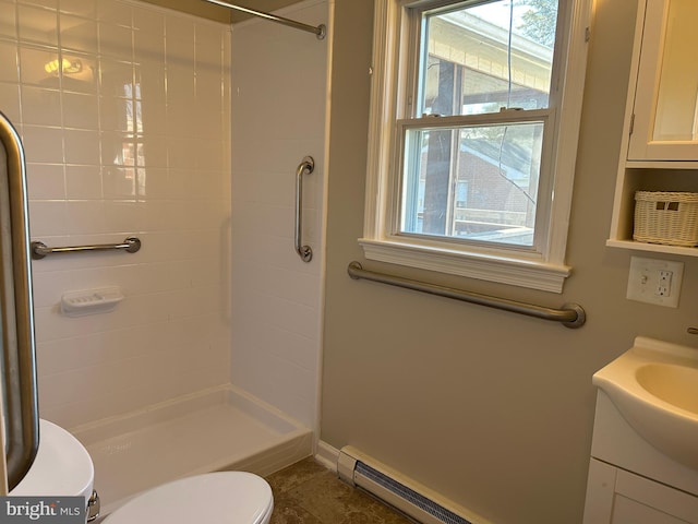 bathroom featuring a tile shower, vanity, a baseboard radiator, and toilet