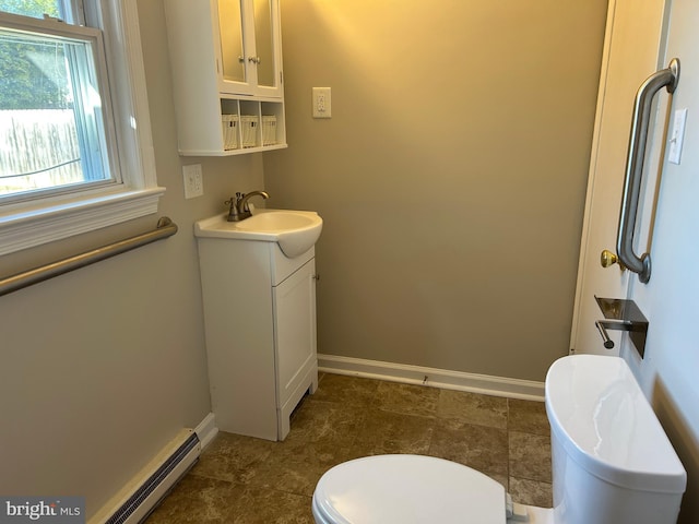 bathroom with vanity, toilet, and a baseboard heating unit