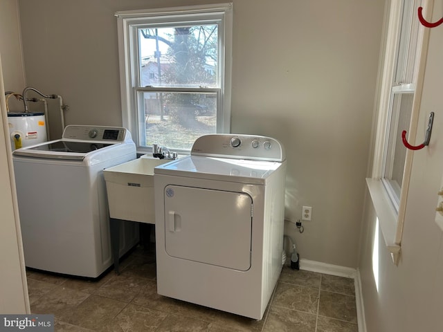 laundry room featuring tile patterned flooring, sink, washer and dryer, and gas water heater