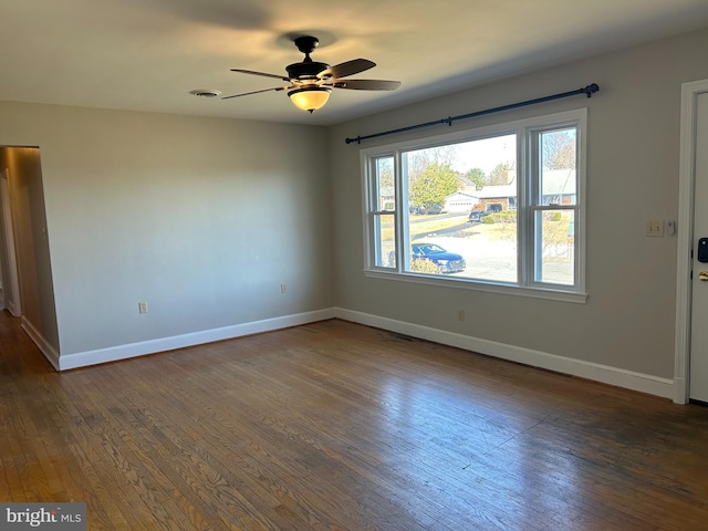 spare room featuring dark wood-type flooring and ceiling fan