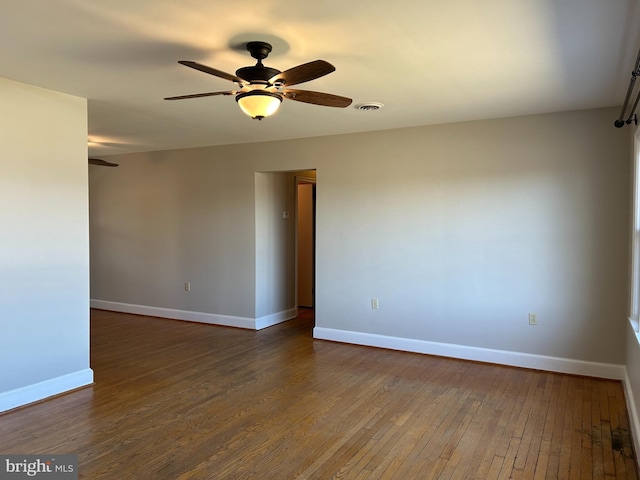 empty room with dark hardwood / wood-style floors and ceiling fan