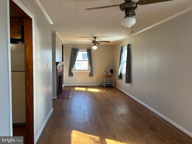 spare room with dark wood-type flooring, ceiling fan, and ornamental molding