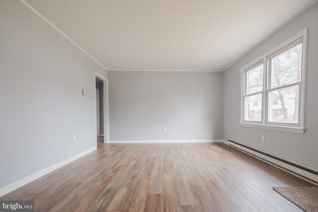 empty room with ornamental molding, a baseboard radiator, and light hardwood / wood-style floors