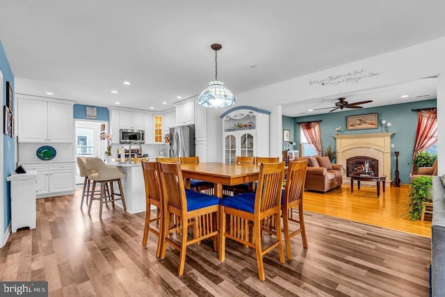 dining space featuring sink, ceiling fan, and light hardwood / wood-style flooring