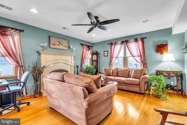 living room featuring light hardwood / wood-style flooring and ceiling fan