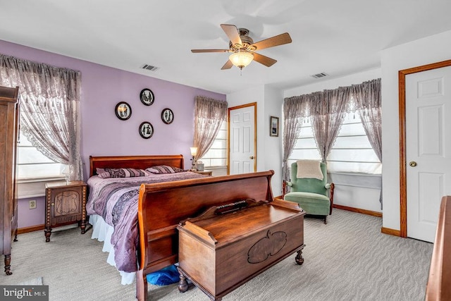 carpeted bedroom with ceiling fan and multiple windows