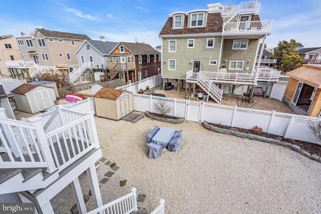 rear view of house with a wooden deck and a storage unit