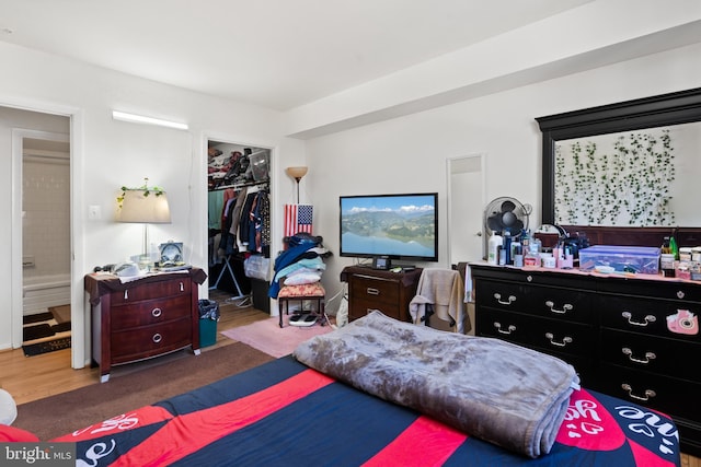 bedroom with a walk in closet, ensuite bathroom, and a closet