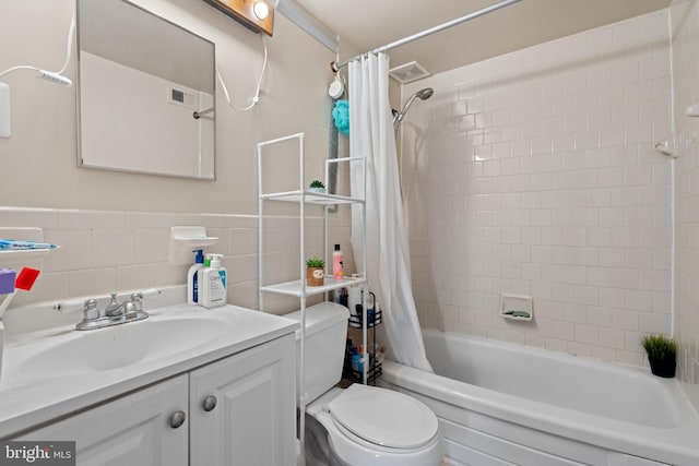 full bathroom featuring vanity, toilet, shower / bath combo with shower curtain, and tile walls