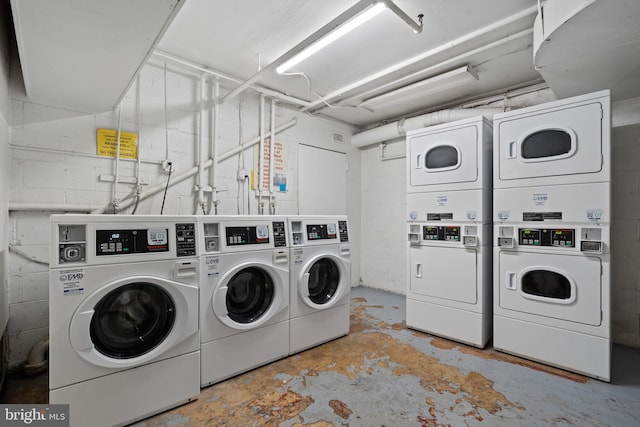 clothes washing area with washer and clothes dryer and stacked washer / dryer