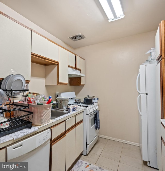 kitchen featuring white cabinetry, white appliances, and light tile patterned flooring