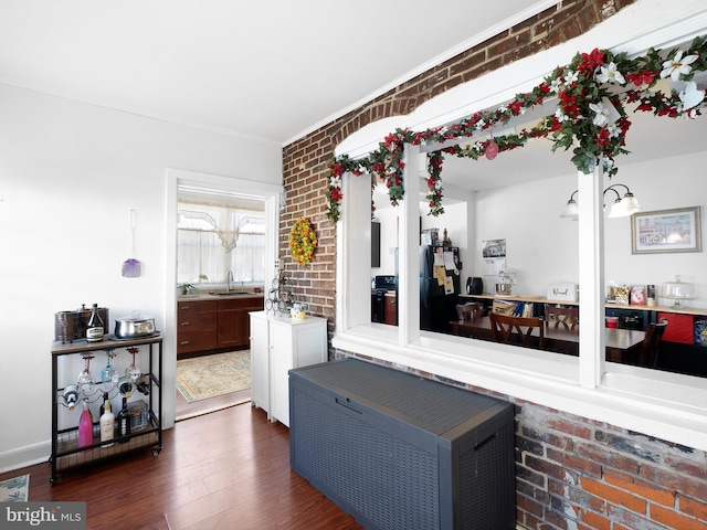 interior space featuring brick wall and dark wood-type flooring