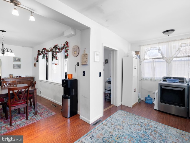 kitchen featuring washer / clothes dryer, light countertops, visible vents, dark wood-type flooring, and baseboards