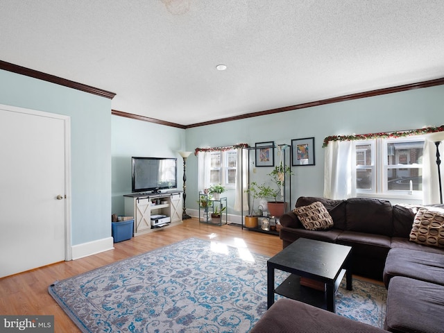 living room with a textured ceiling, baseboards, light wood-style flooring, and crown molding