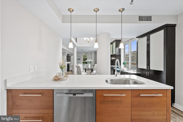 kitchen featuring sink, a wealth of natural light, stainless steel dishwasher, and hanging light fixtures