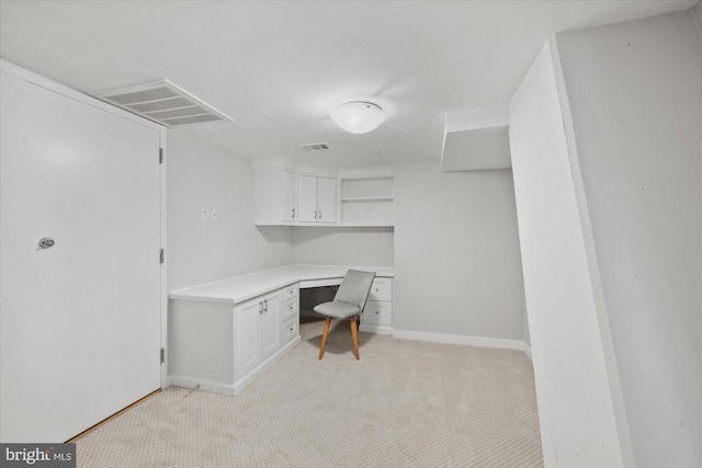 unfurnished office featuring light carpet and built in desk