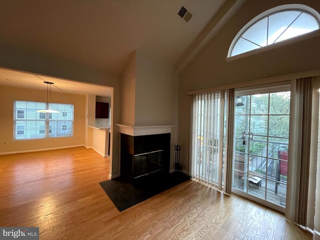 unfurnished living room with lofted ceiling and light wood-type flooring