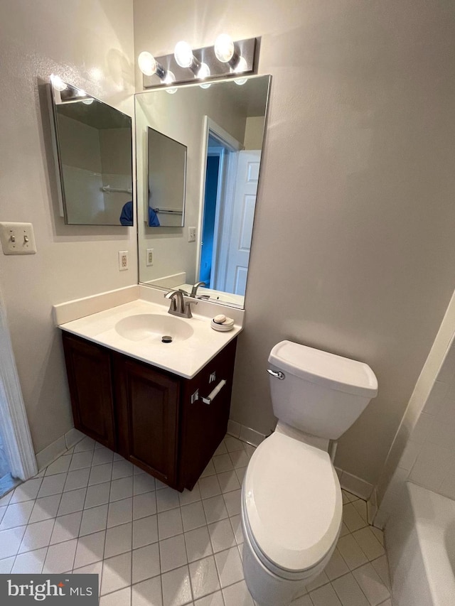 bathroom featuring tile patterned floors, vanity, toilet, and a bathtub