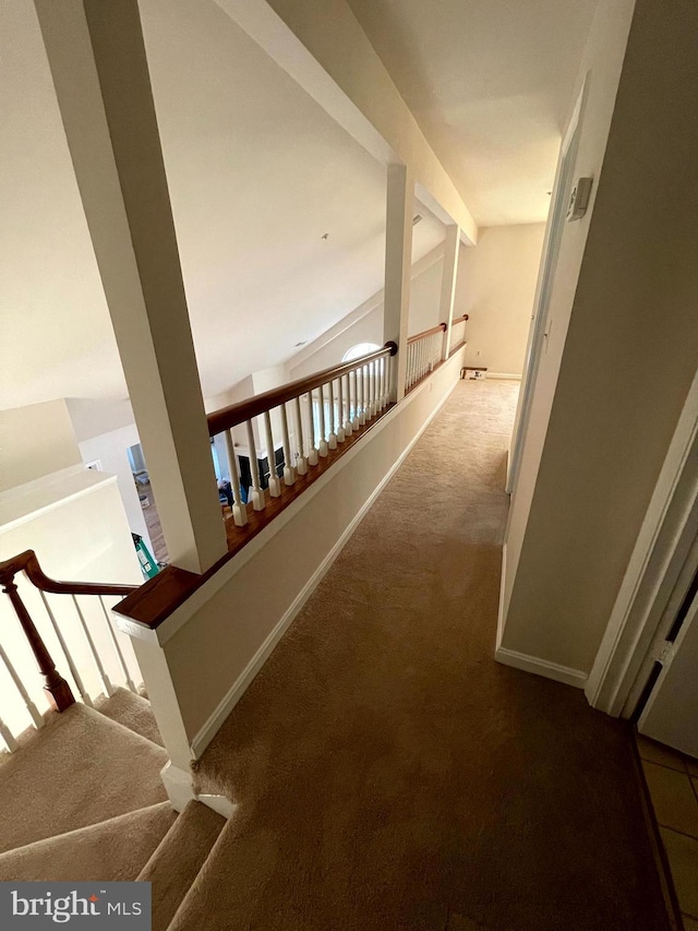 hall with beamed ceiling and carpet flooring