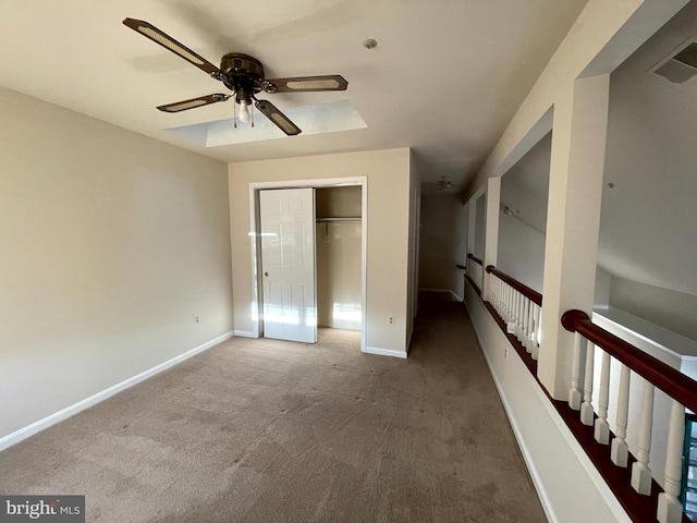 unfurnished bedroom featuring carpet, ceiling fan, and a closet