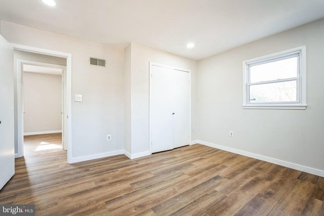 unfurnished bedroom featuring hardwood / wood-style floors and a closet