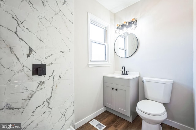 bathroom with hardwood / wood-style flooring, vanity, and toilet