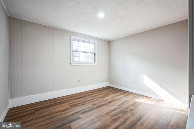 spare room featuring hardwood / wood-style floors and a textured ceiling