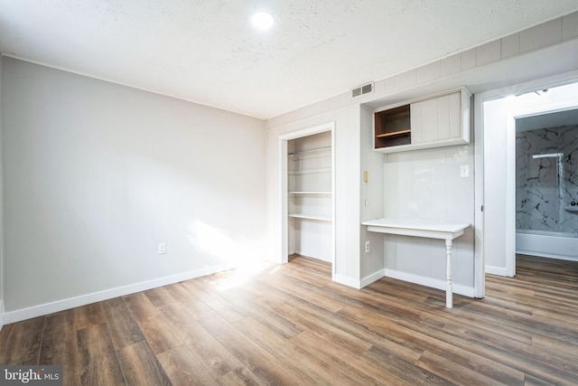 interior space featuring dark hardwood / wood-style floors, a textured ceiling, and a closet