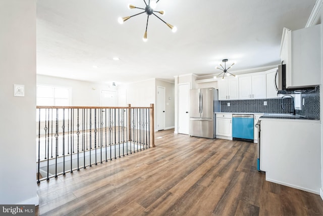 kitchen with white cabinetry, dark wood-type flooring, a chandelier, and appliances with stainless steel finishes