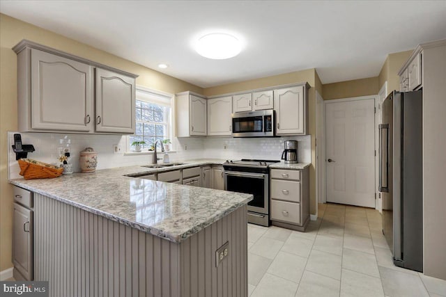 kitchen featuring sink, gray cabinetry, stainless steel appliances, tasteful backsplash, and kitchen peninsula