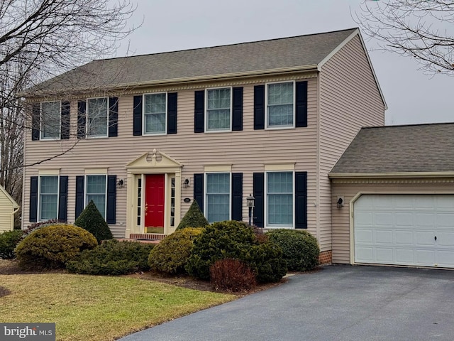 colonial-style house with a garage and a front yard