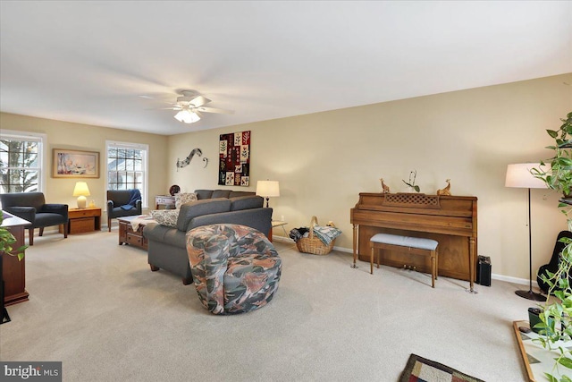 carpeted living room with ceiling fan