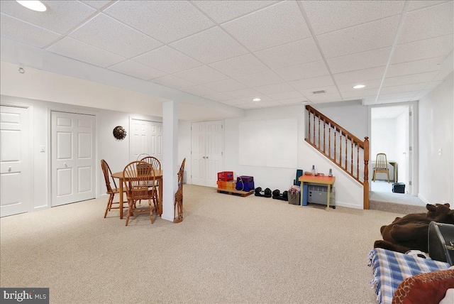 dining space with a drop ceiling and carpet