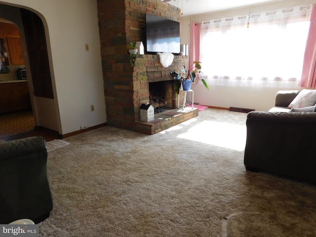 carpeted living room with a brick fireplace