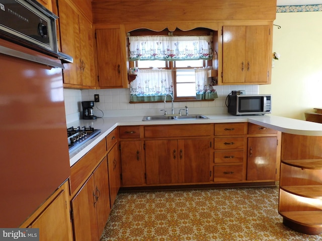 kitchen with tasteful backsplash, sink, and appliances with stainless steel finishes