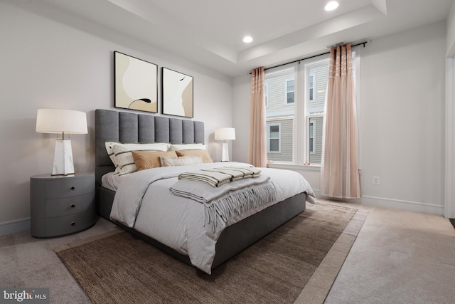 carpeted bedroom featuring a tray ceiling