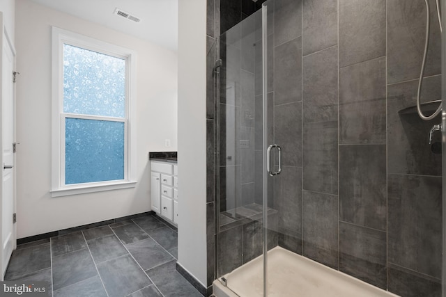 bathroom with vanity, a healthy amount of sunlight, and walk in shower