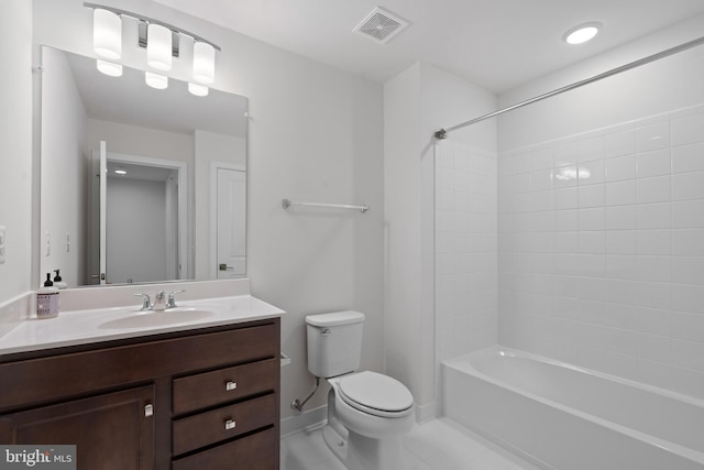 full bathroom with tiled shower / bath, vanity, and toilet