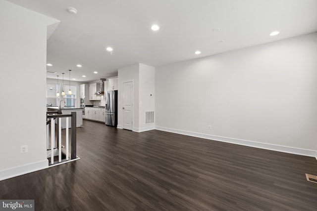 unfurnished living room featuring dark hardwood / wood-style flooring and sink