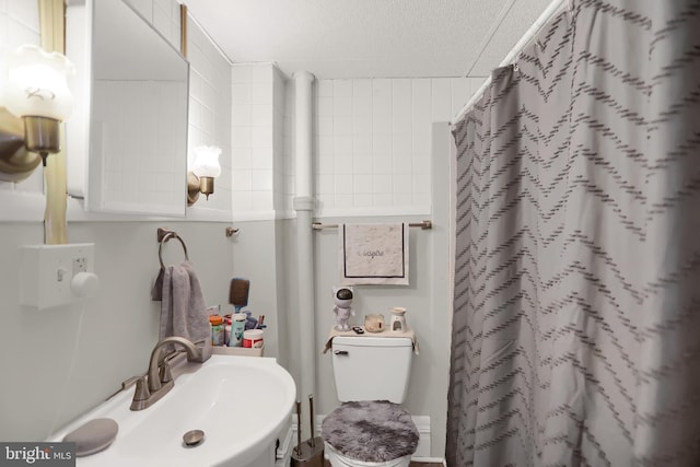 bathroom with sink, a shower with curtain, and toilet