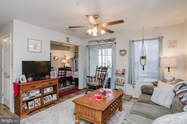 living room featuring ceiling fan and light hardwood / wood-style flooring