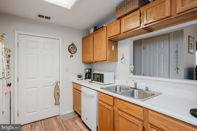 kitchen with sink, white appliances, and light hardwood / wood-style floors